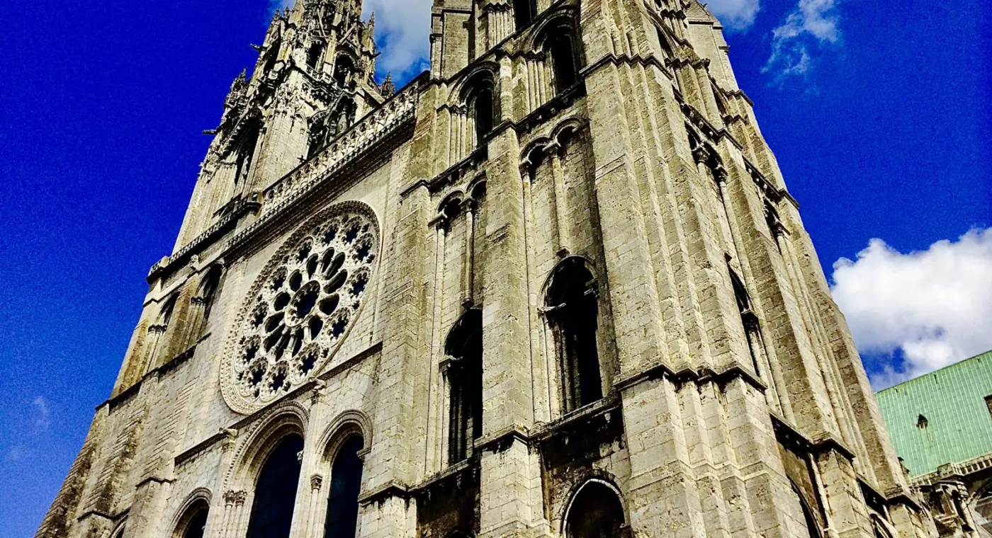 Torre gótica de uma catedral em pedra contra o céu azul