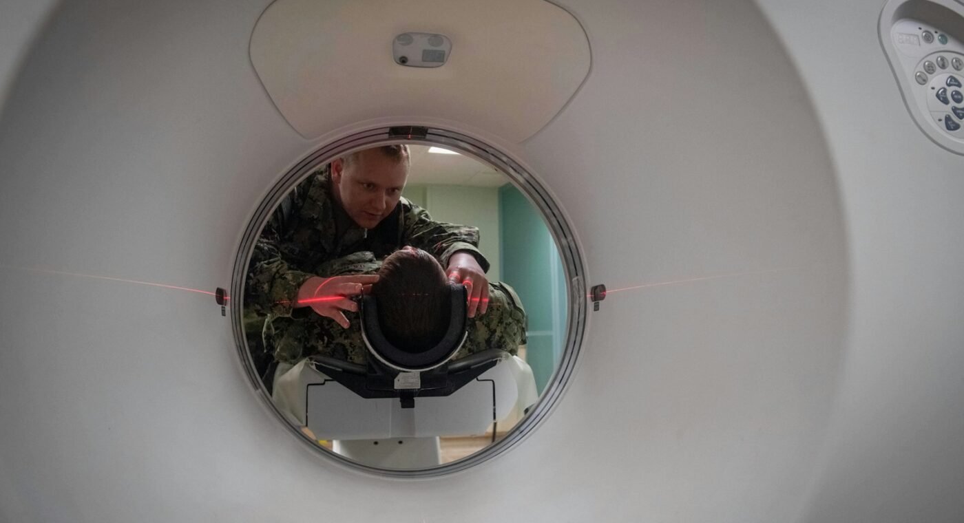 Profissional posicionando um paciente num tomógrafo