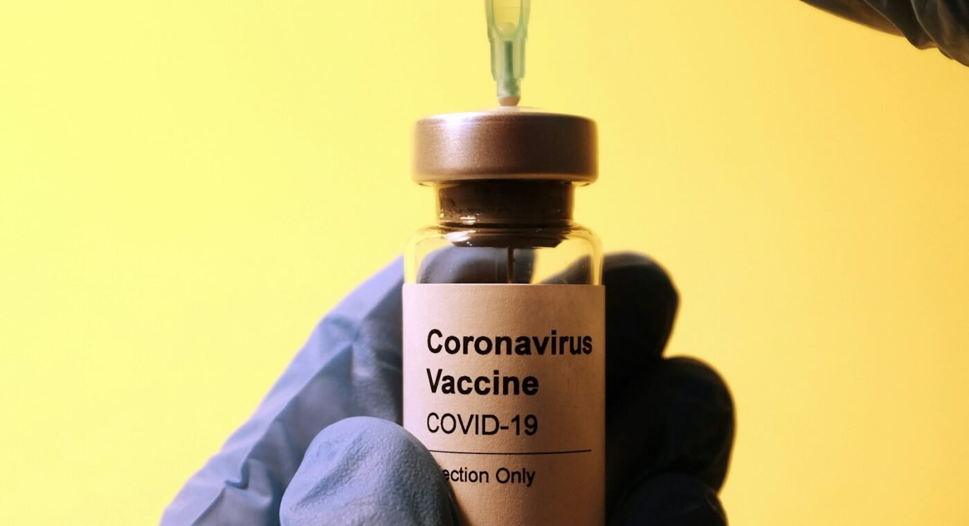 Profissional de laboratório segurando um frasco de vacina