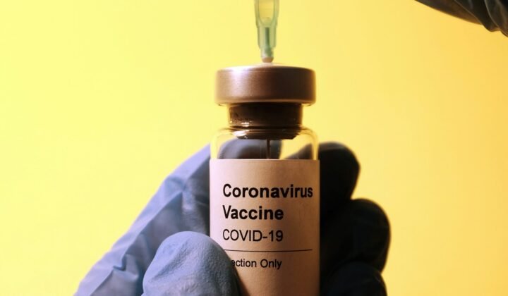 Profissional de laboratório segurando um frasco de vacina